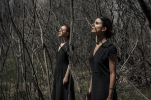 Two women models wearing black dresses in the woods