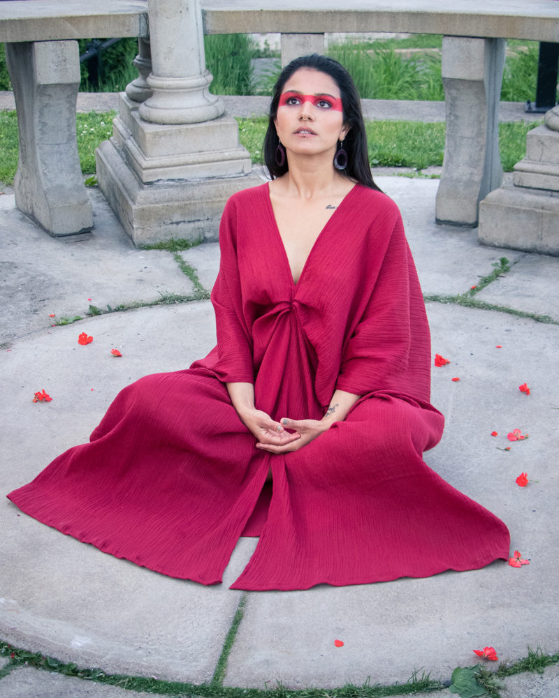Woman meditating wearing an organic red dress in a temple