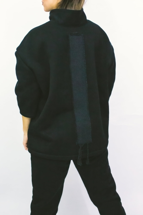 Woman wearing black high-collar sweatshirt
