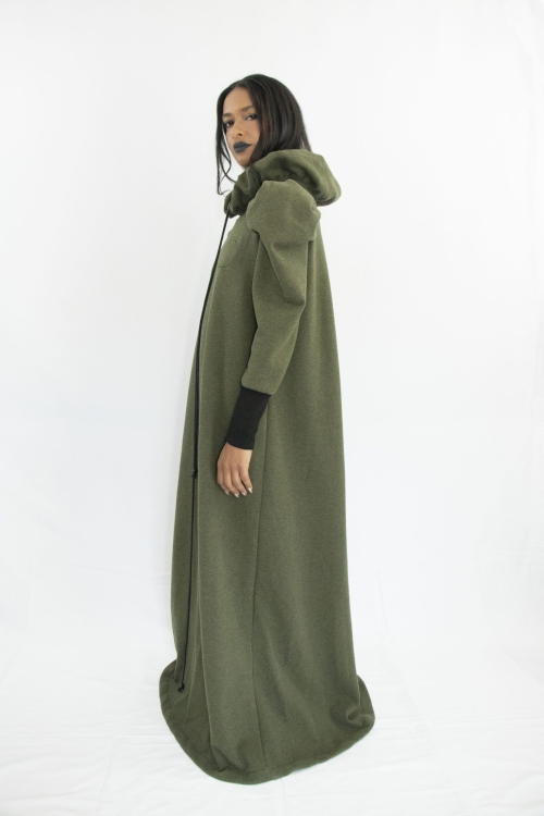 Woman wearing long forest green dress in organic cotton with gathered ruff collar and draw strings, puffy sleeves and long rib cuffs