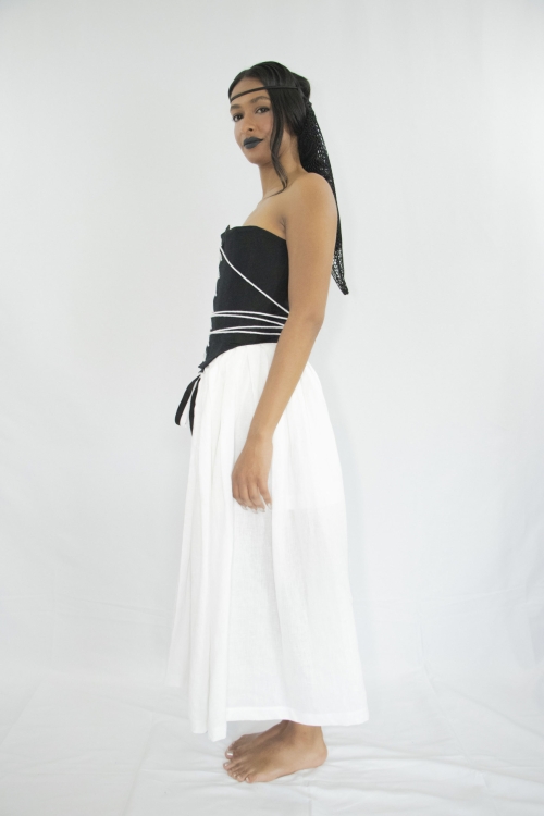 Woman wearing white and black tea-lenght linen pleated skirt