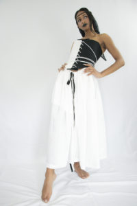 Woman wearing white and black tea-lenght linen pleated skirt