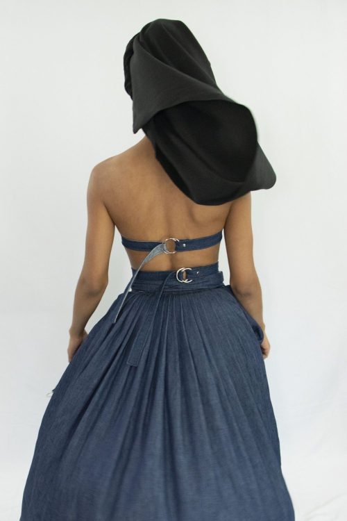 Woman wearing dark blue denim corset with straps buckled and tied at the back in zero waste cotton