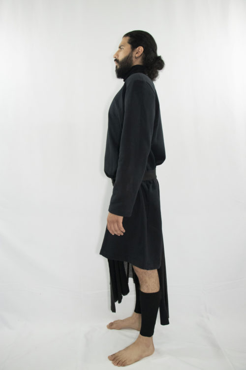 Man wearing black assymetric pleated kilt with front pocket and snap-belt made from zero waste and organic materials