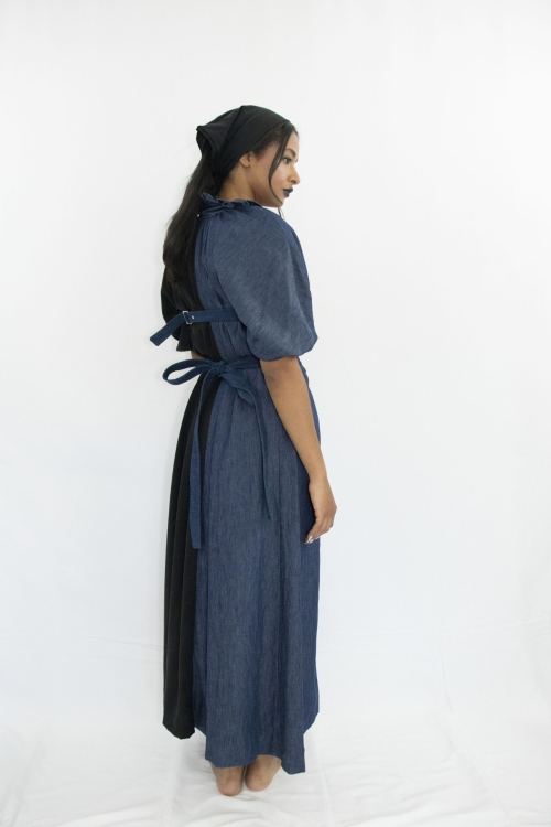 Woman wearing black and blue long a-line dress with ruff collar and gathered kimono sleeves made from organic hemp, cotton and sustainable lyocell