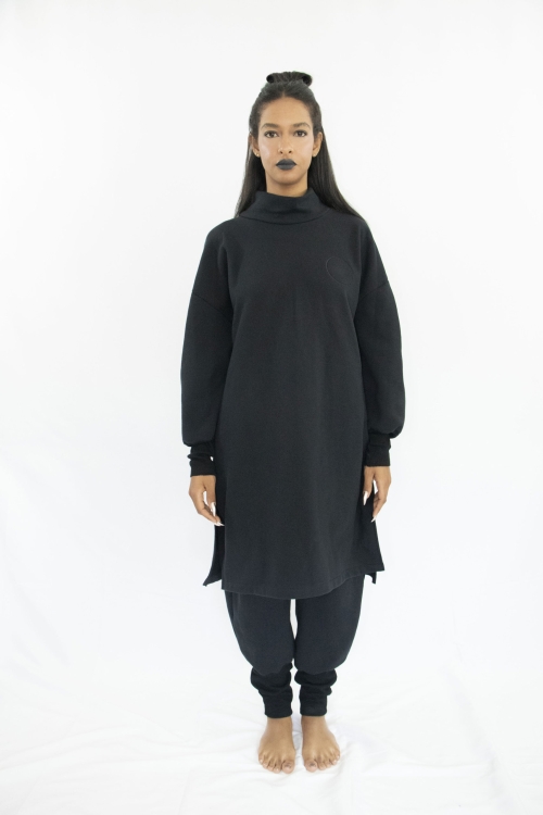 Woman wearing organic black unisex tunic with long sleeves and high collar