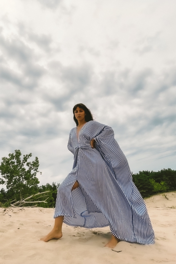 Woman wearing long blue kaftan goddess dress on the sand dunes